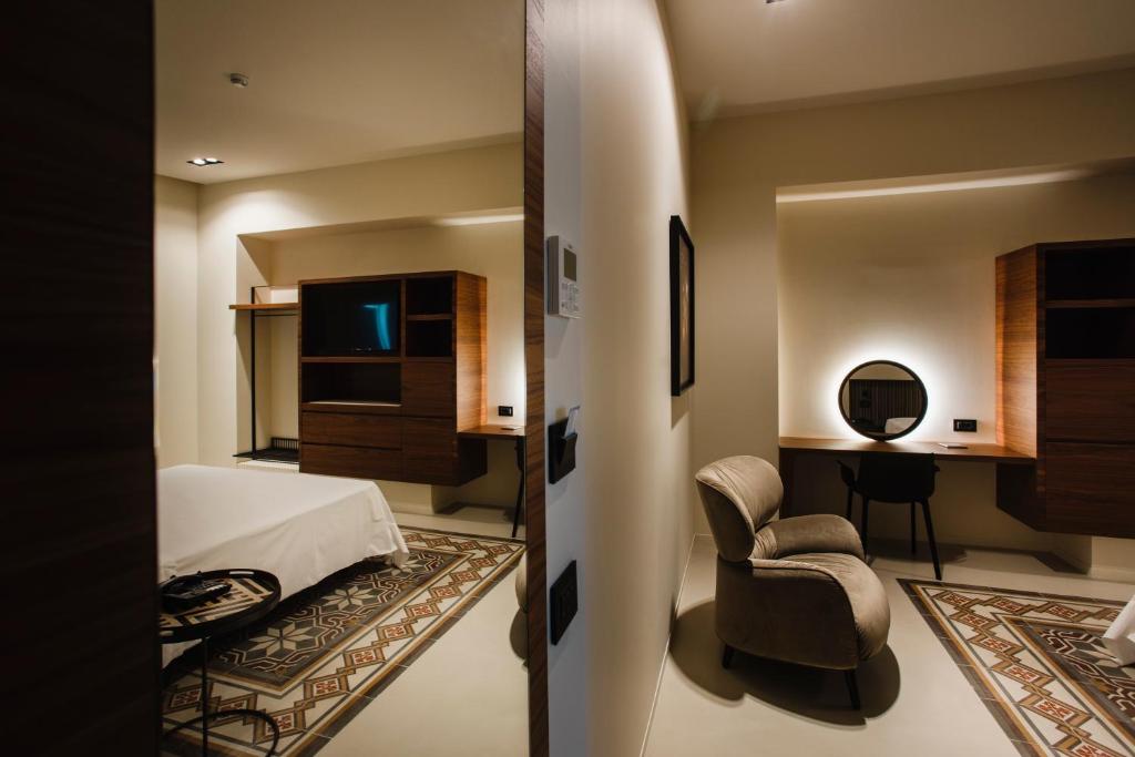 マテーラにあるPalazzo della Fontanaのベッドルーム1室(ベッド1台、椅子、デスク付)