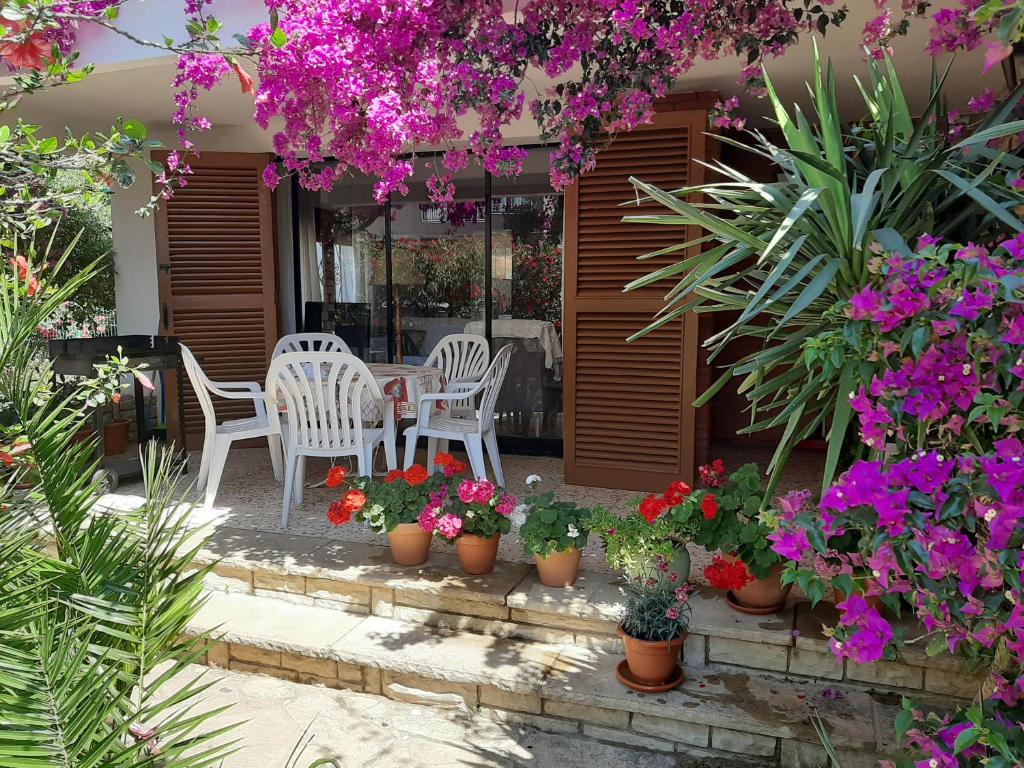 un patio con tavoli, sedie e fiori di Casa Franch a Hospitalet de l'Infant