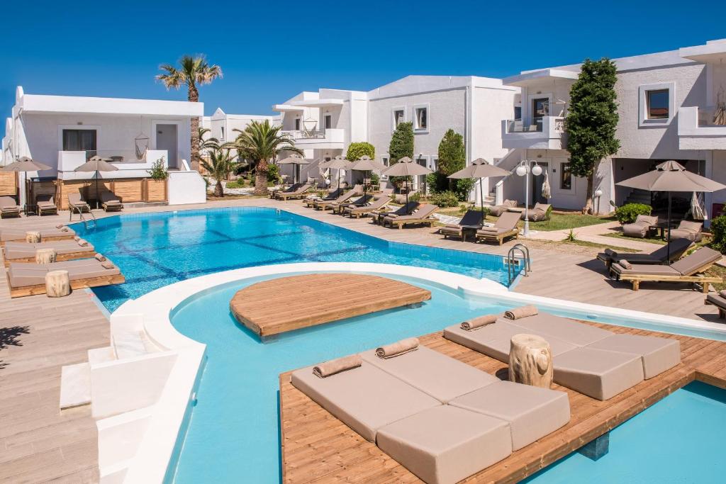 uma imagem de uma piscina num resort com espreguiçadeiras em Enorme Maya Beach Hotel-Adults Only em Gouves