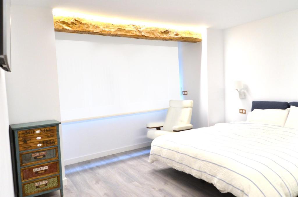 a bedroom with a bed and a dresser and a window at Luxury Pintoreria Vitoria in Vitoria-Gasteiz