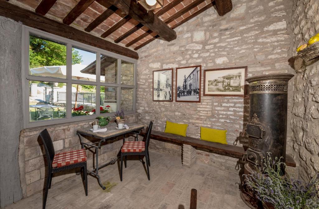 une chambre avec une table, des chaises et une fenêtre dans l'établissement I Casali di Villa Benveduti, à Gubbio