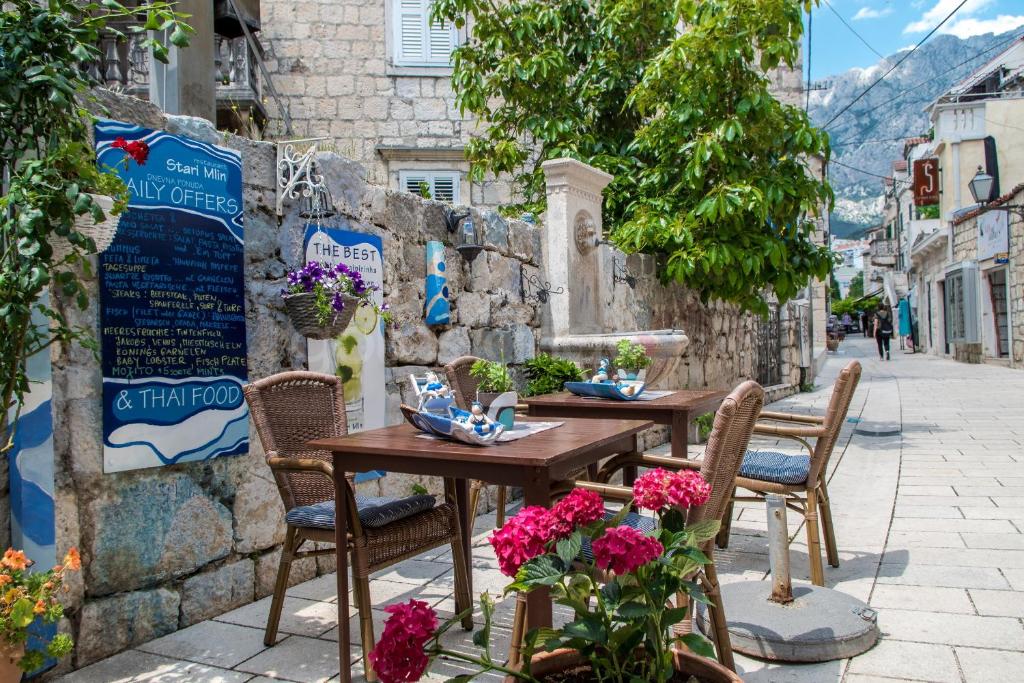 a table and chairs on a street with flowers at Luxury Rooms Palace B&B in Makarska