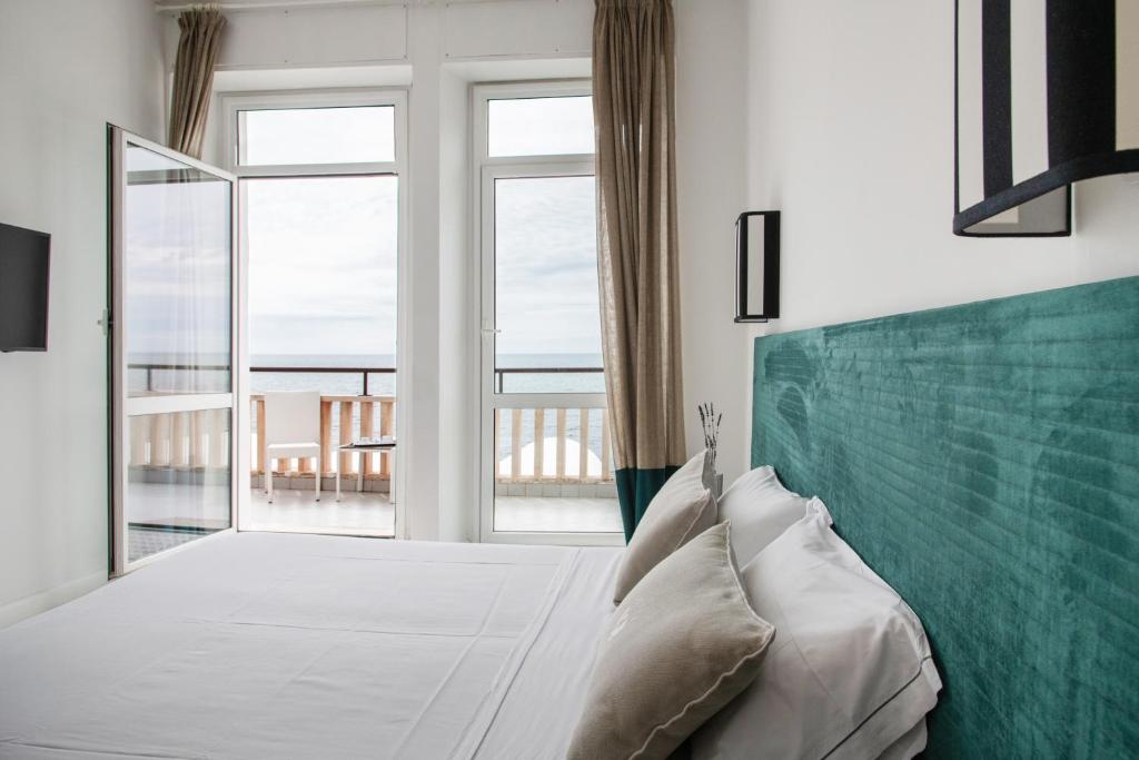 a bedroom with a bed and a large window at Villa delle Palme in Santa Marinella