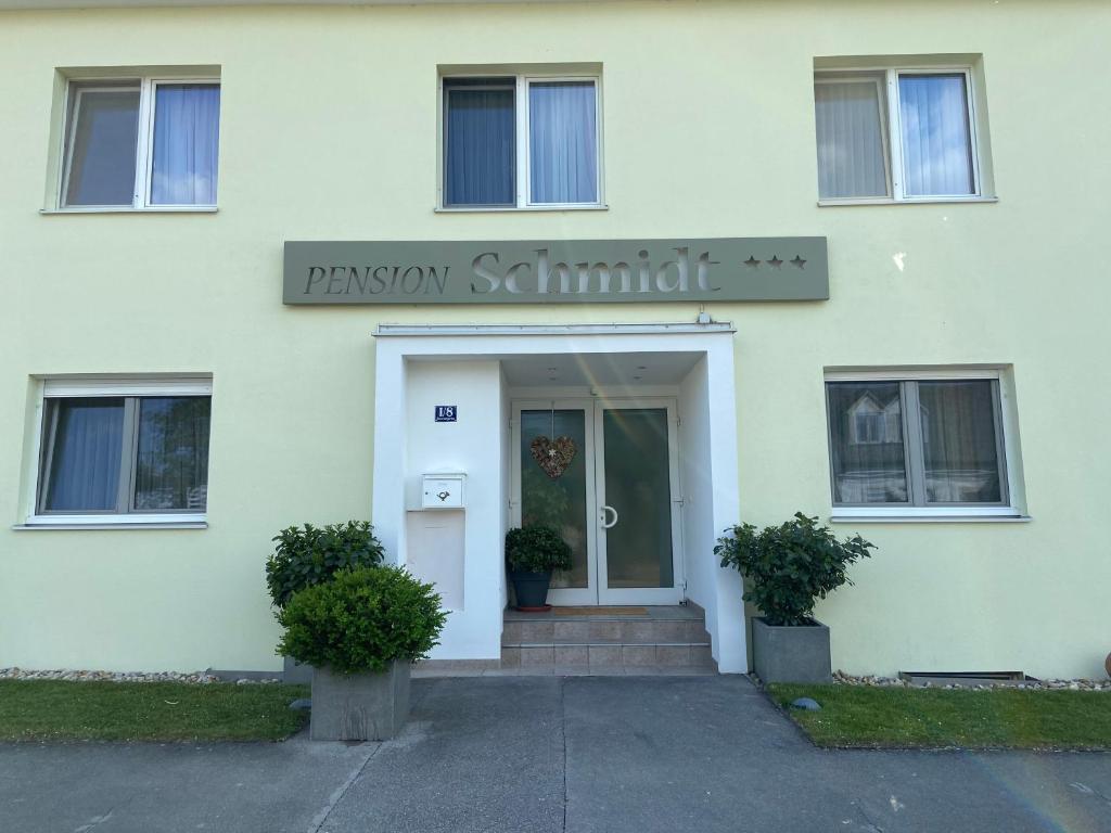 un edificio blanco con un cartel que lee seminario de pasión en Pension Schmidt en Podersdorf am See