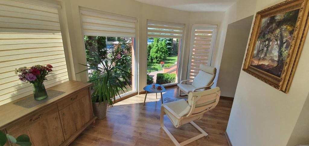 a living room with two chairs and a window at Šarlotos apartamentai in Klaipėda