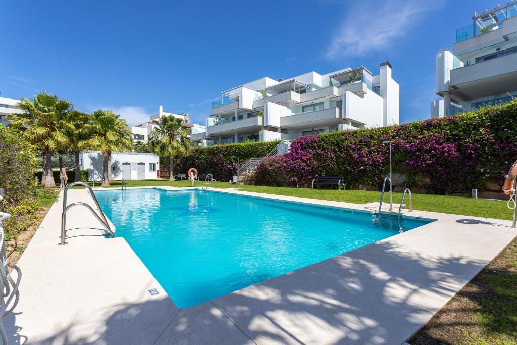 una piscina frente a un edificio en Janssun Cabopino Luxury Apartment by GHR Rentals, en Marbella