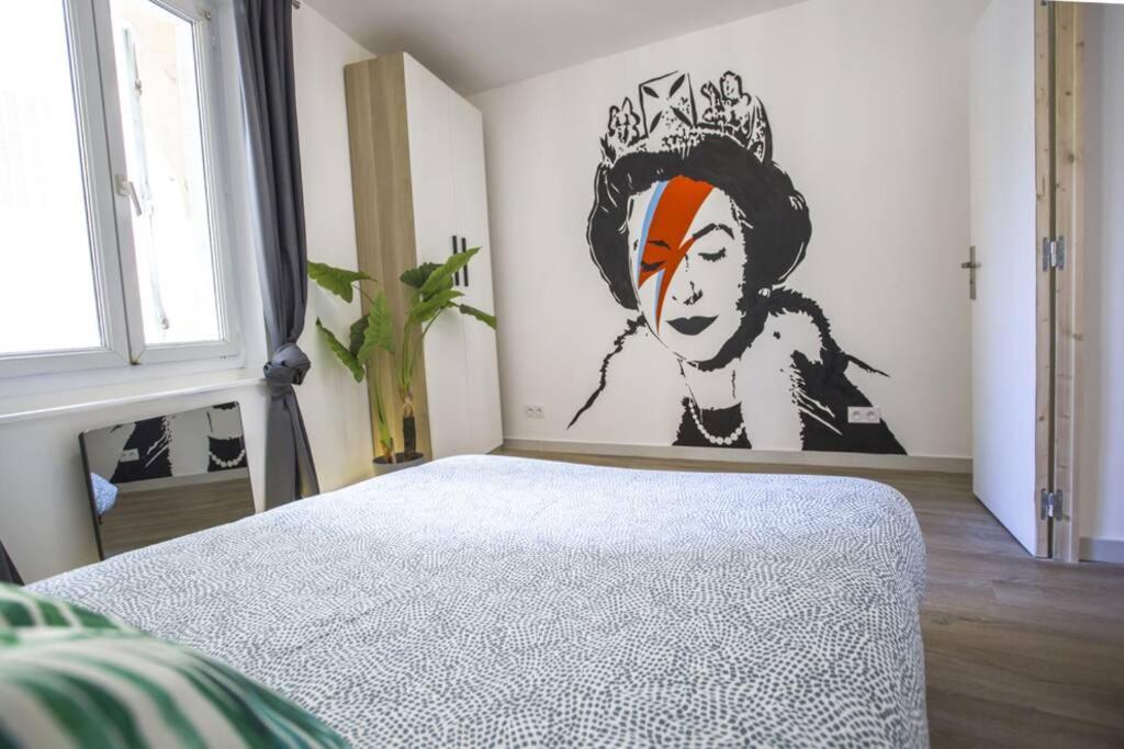 a bedroom with a bed with a painting on the wall at GregBnb-com - Centre Ancien - T2 Street Art - Wifi in Toulon