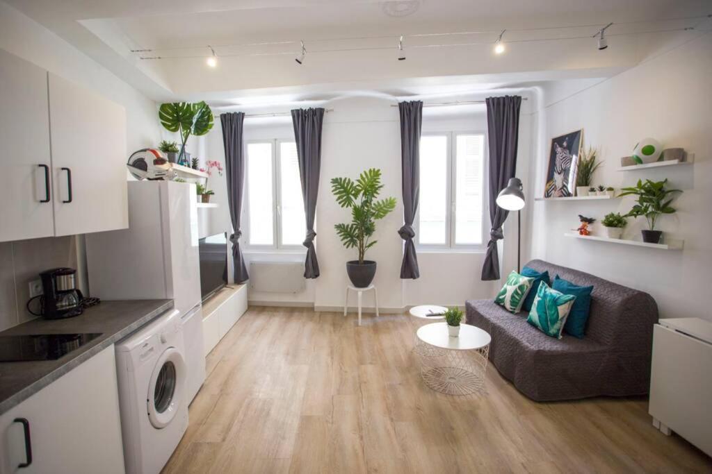 un salon avec un canapé et quelques fenêtres dans l'établissement GregBnb - Centre Ancien - T2 Street Art - Wifi, à Toulon