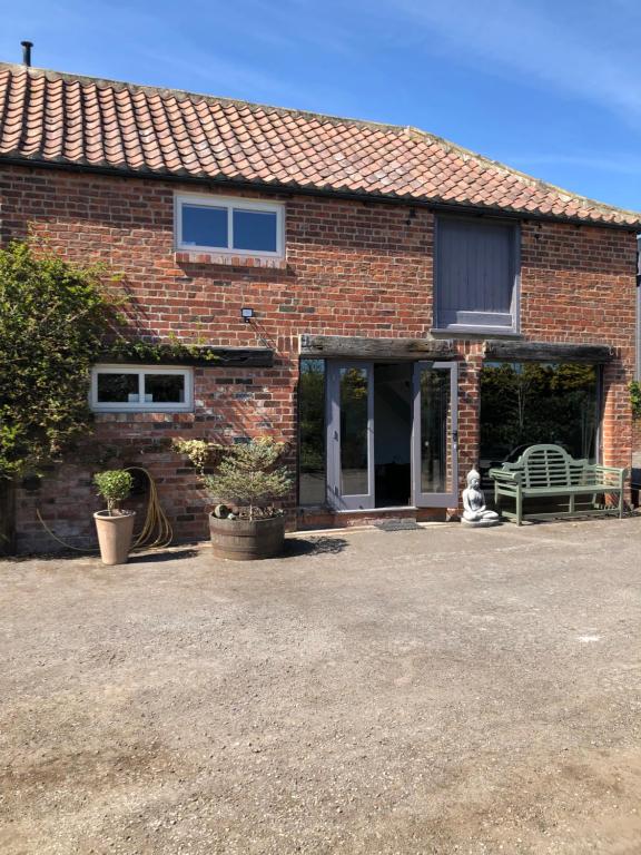 a brick house with a bench in front of it at Impeccable cottage suitable for Three adults in Tockwith