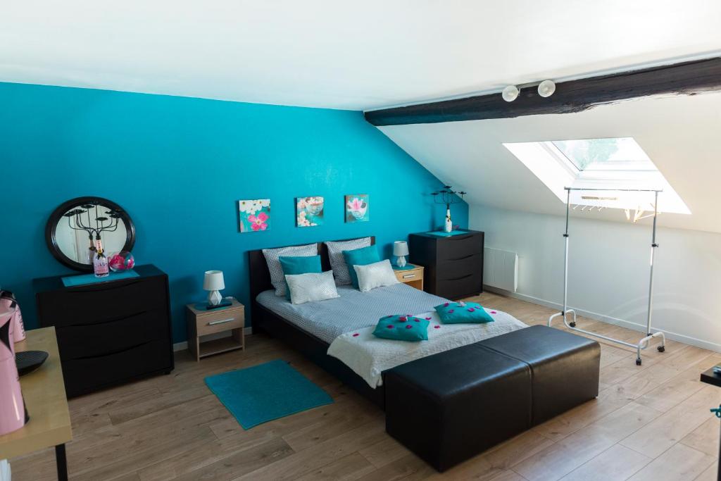 - une chambre avec des murs bleus, un lit et un bureau dans l'établissement Escale à Épernay, à Épernay