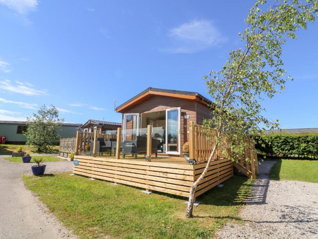 a tiny house with a large window on a yard at Eden Lodge - Sherwood 21 in Carnforth