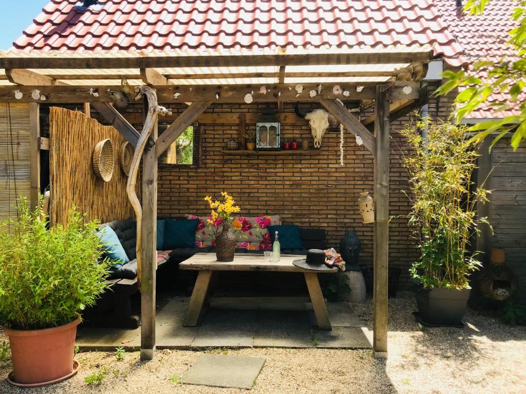 een houten pergola met een tafel in een patio bij Vakantiehuis Boulevard in Vlissingen
