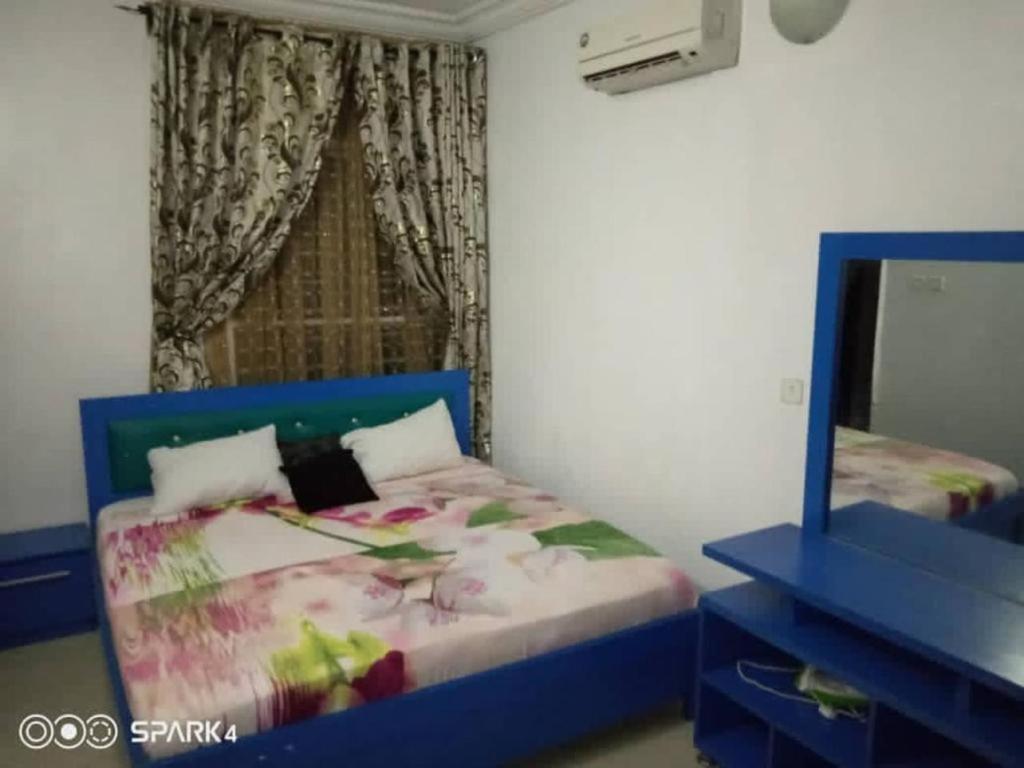 a bedroom with a blue bed and a mirror at executive 4bedrooms house in Lagos Nigeria in Lekki