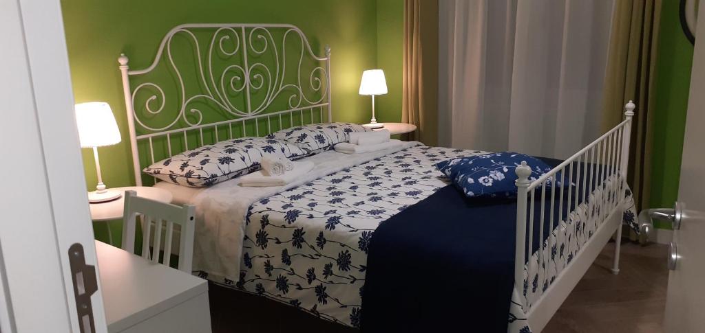 um quarto com uma cama com um edredão branco e azul em B&B Stella Scugnizza em Nápoles