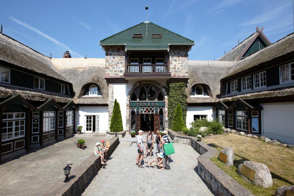 a group of people sitting in the courtyard of a building at Hotel Forsthaus Damerow in Ostseebad Koserow