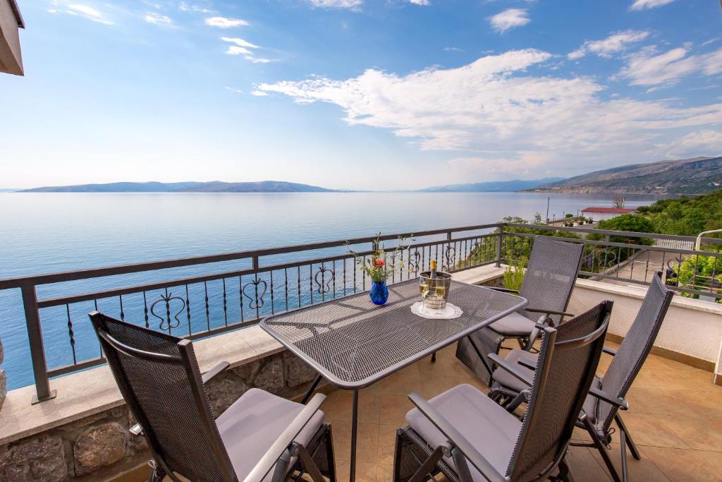 a balcony with a table and chairs and a view of the water at Villa Arca Adriatica in Sveti Juraj