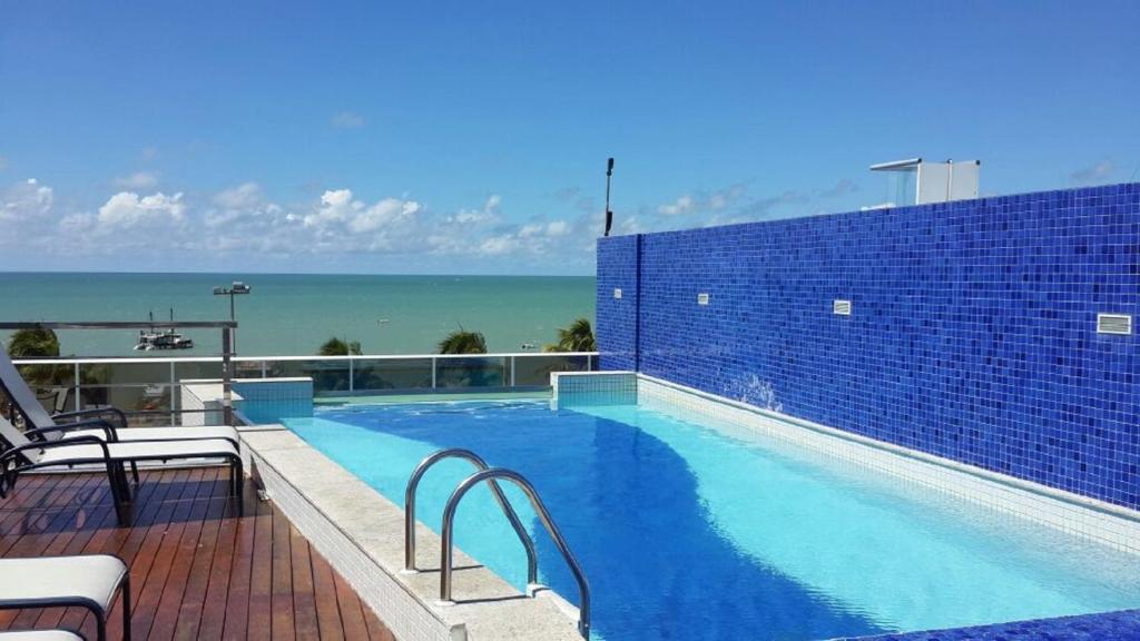 a swimming pool with a view of the ocean at Sol e Mar Solar do Atlântico-Tambaú-João Pessoa in João Pessoa