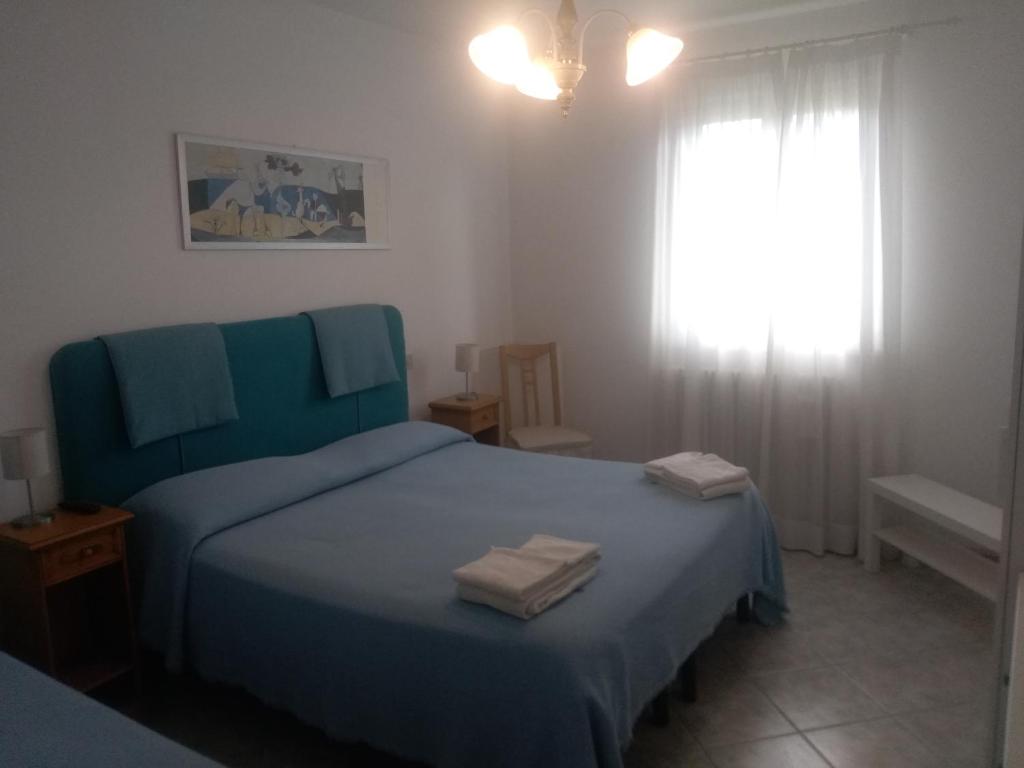 een slaapkamer met een blauw bed met 2 handdoeken erop bij Maison La Vela in Forte dei Marmi