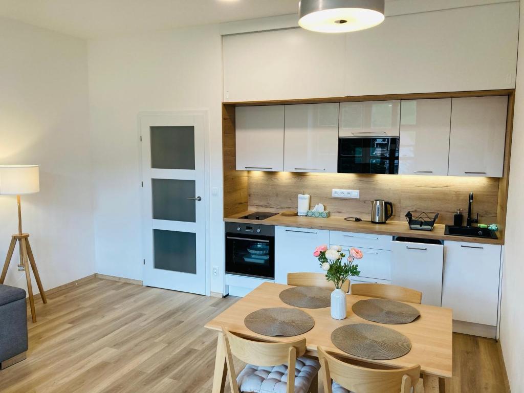 a kitchen with a table and chairs in a kitchen at Residence Kotel in Rokytnice nad Jizerou