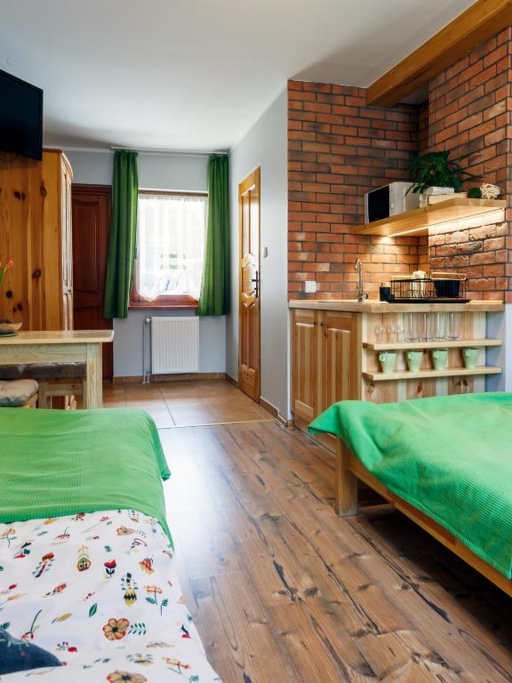 a room with a bed and a table and a kitchen at Pokoje u Karolinki in Zakopane