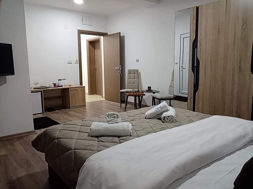 een slaapkamer met 2 bedden en handdoeken bij Dany Apartments in Gevgelija