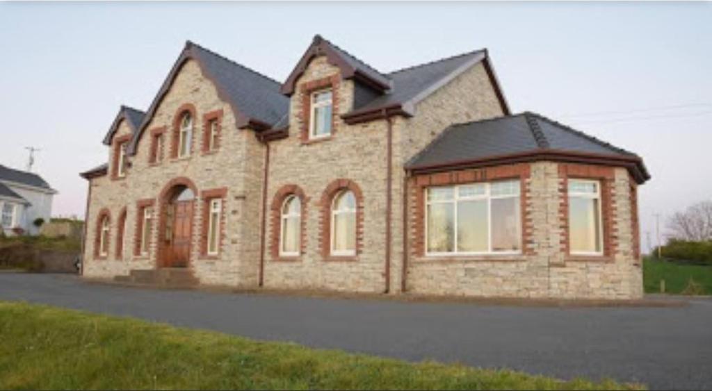 a large brick house on the side of a street at Ballylawn Lodge in Letterkenny