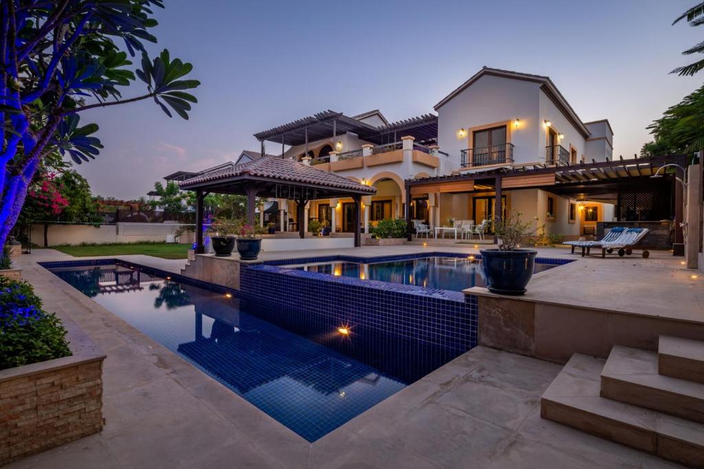 a home with a swimming pool in front of a house at Frank Porter - The Villa, Ponderosa in Dubai