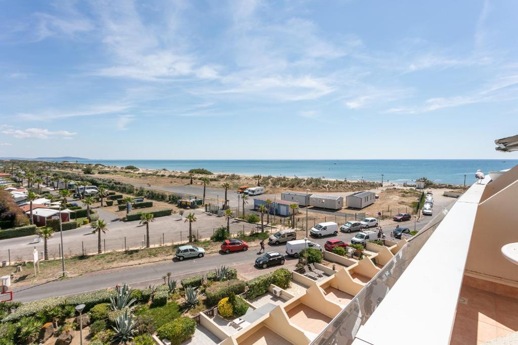 une vue sur la plage depuis le balcon d'un immeuble dans l'établissement Village Naturiste R4N - Le Blue Light Heliopolis Sea View Luxe, au Cap d'Agde
