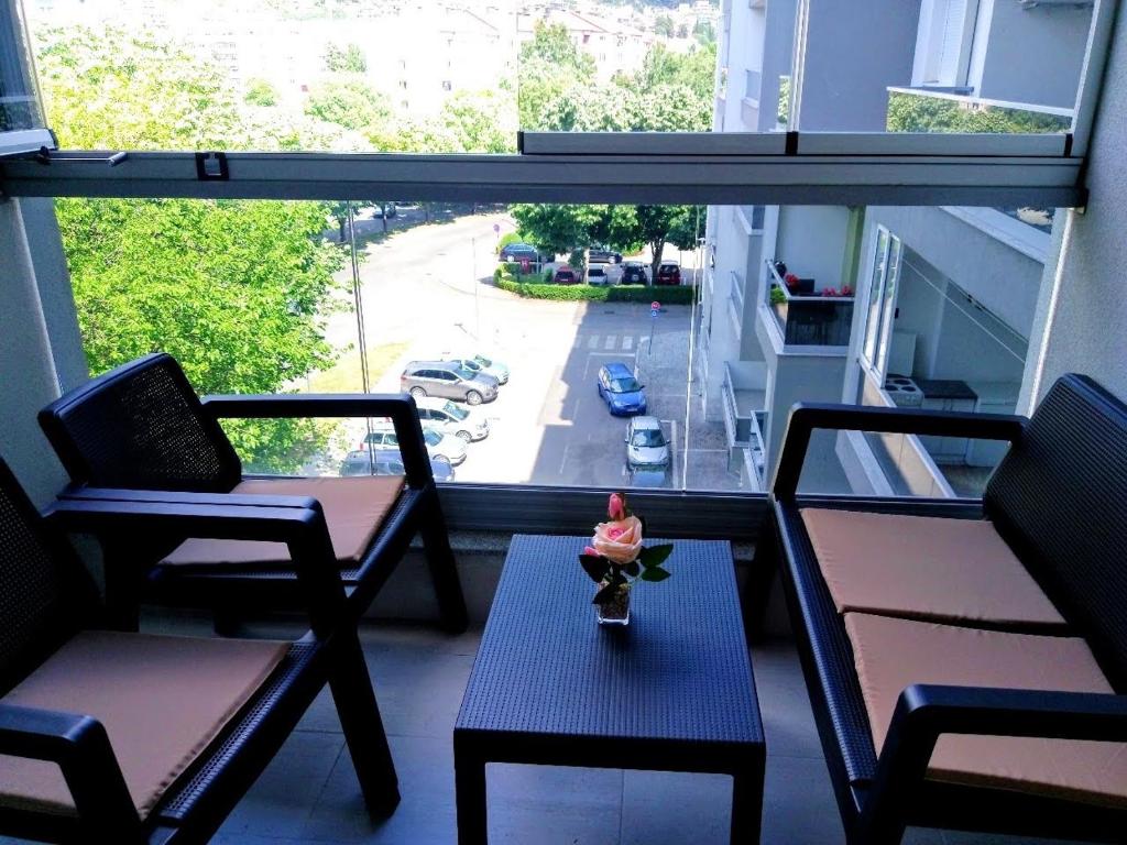 um quarto com duas cadeiras, uma mesa e uma janela em Soba s pogledom em Trebinje