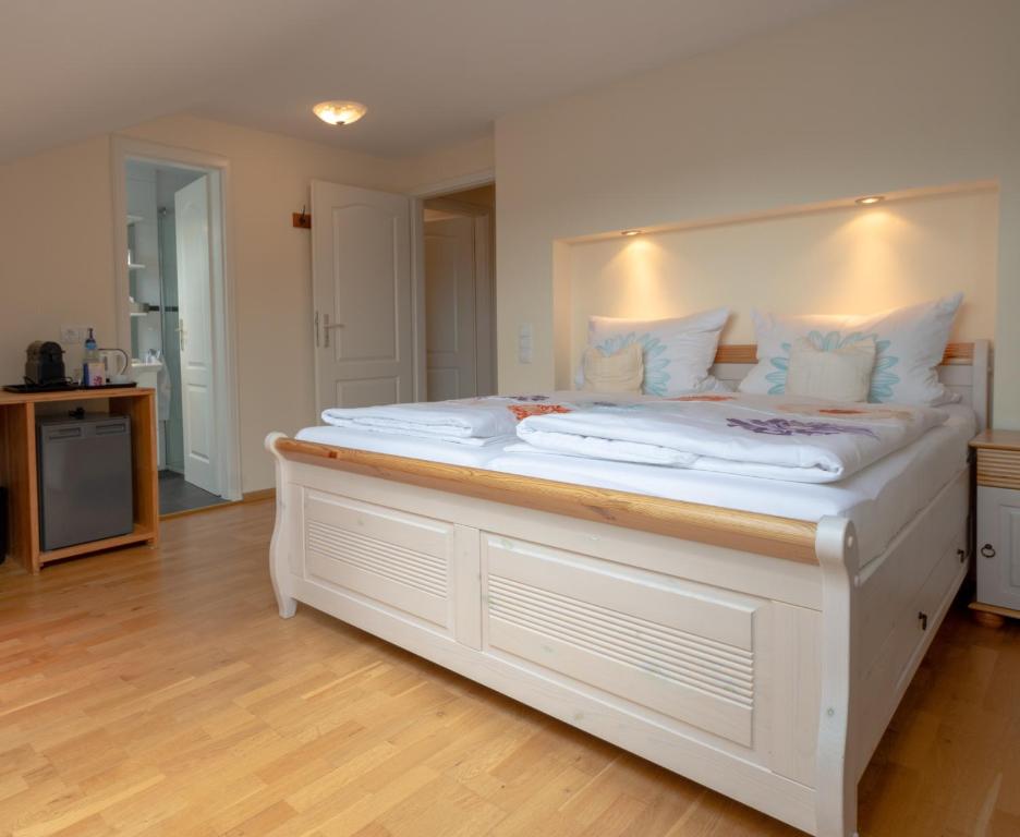 a large white bed with white pillows on it at Gästehaus Casa Cristina in Bad Krozingen