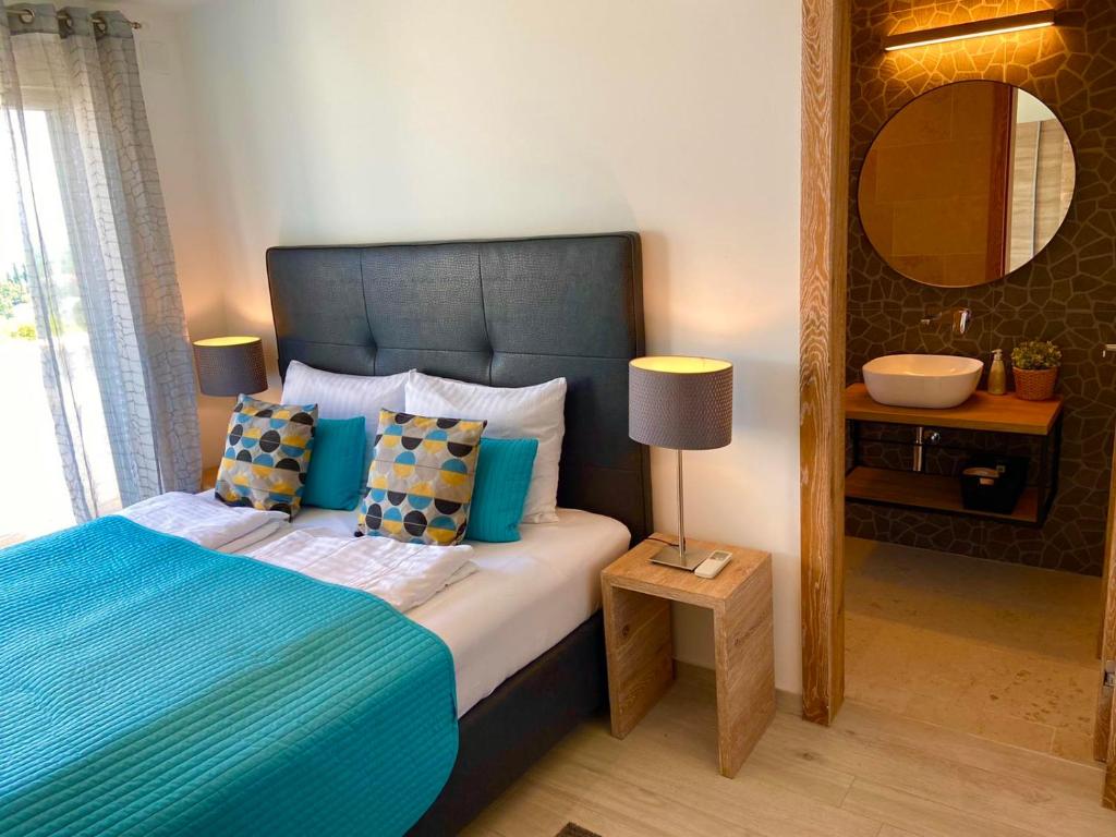 um quarto com uma cama com um edredão azul e um espelho em Villetta Mia em Njivice