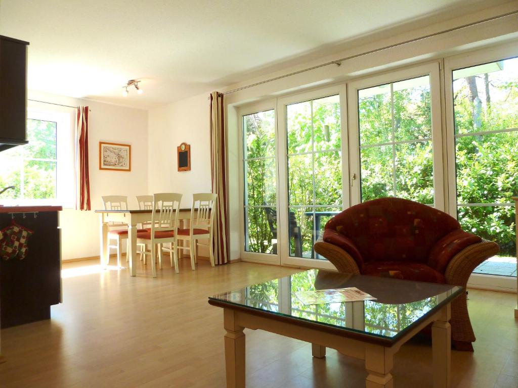 a living room with a couch and a glass table at Apartementhäuser Marlene & Olivia in Juliusruh