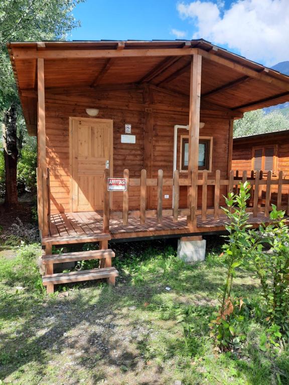 a log cabin with a sign in front of it at Barumi-Bungalow Leonardo in Porlezza
