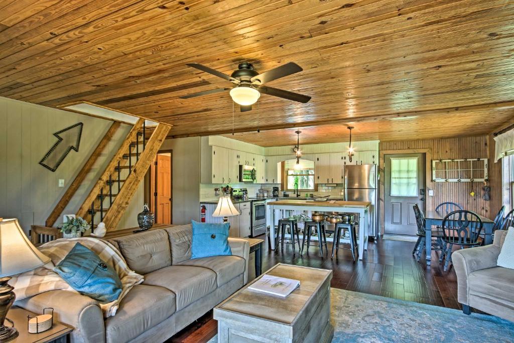 a living room with a couch and a ceiling fan at Lakefront Waterloo Cabin with Dock, Kayaks and Grill! in Waterloo