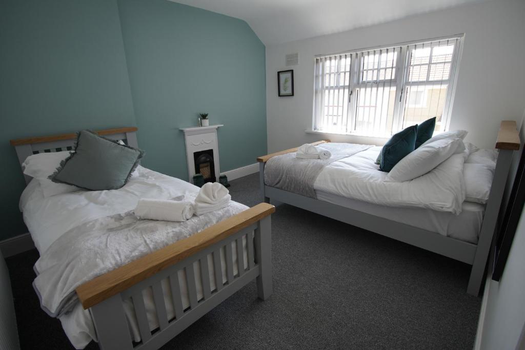 a bedroom with two beds and a window at Risca Retreat in Risca