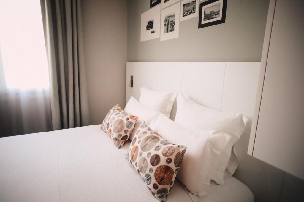 a bedroom with a white bed with pillows on it at Best Western Plus La Corniche in Toulon