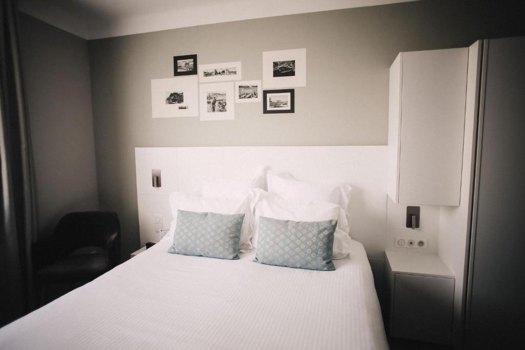 a bedroom with a white bed with two pillows at Best Western Plus La Corniche in Toulon