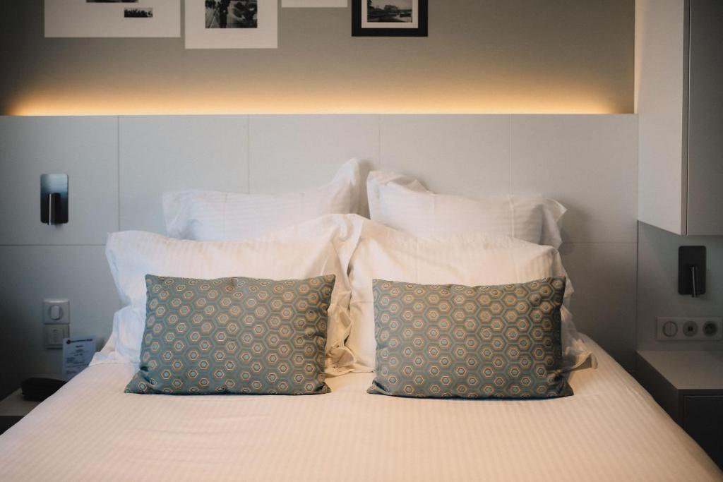 a white bed with two pillows on top of it at Best Western Plus La Corniche in Toulon