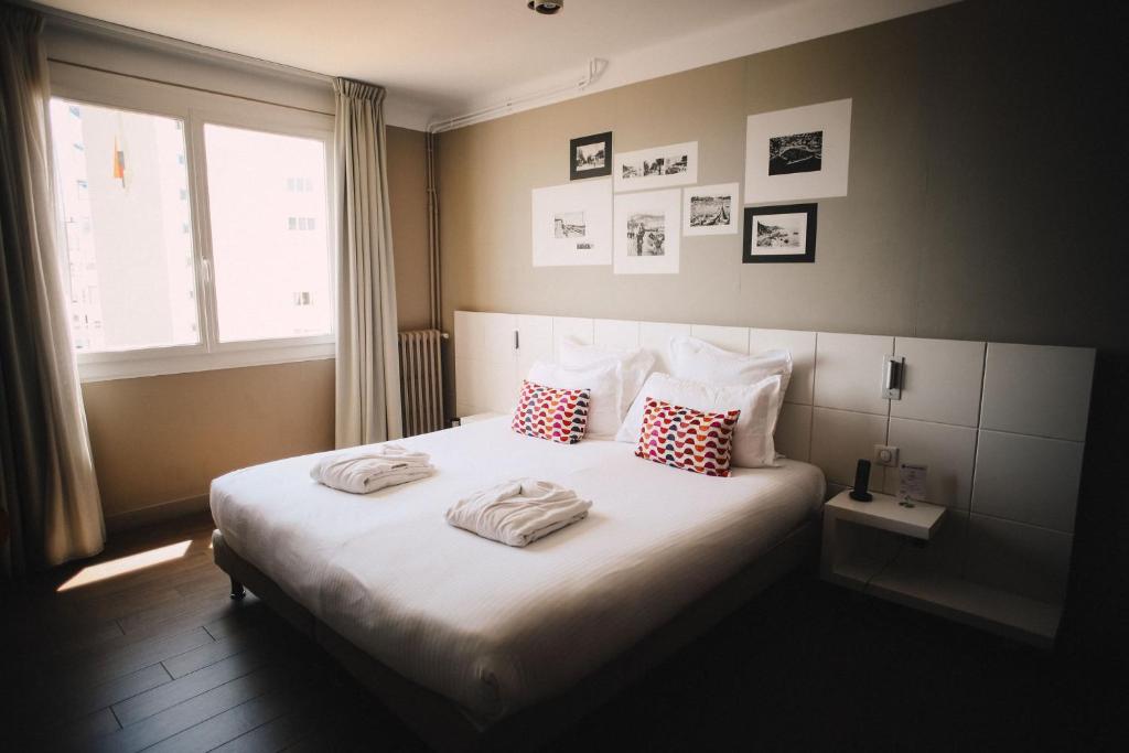 a bedroom with a bed with two towels on it at Best Western Plus La Corniche in Toulon