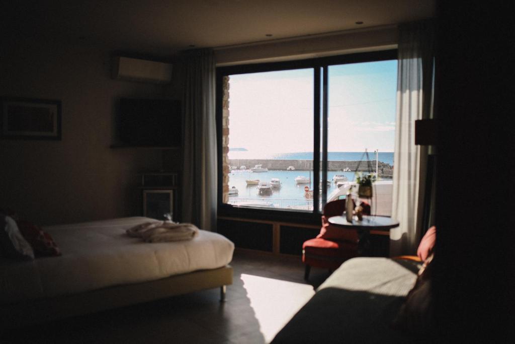 a bedroom with a large window with a view of a harbor at Best Western Plus La Corniche in Toulon