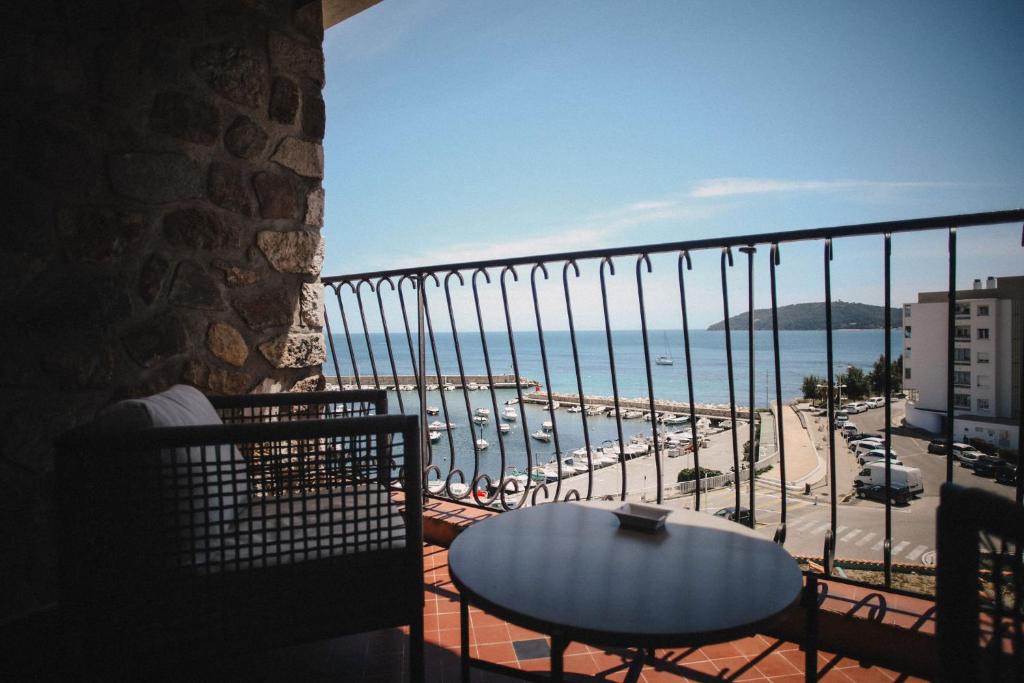a balcony with a table and a view of the beach at Best Western Plus La Corniche in Toulon
