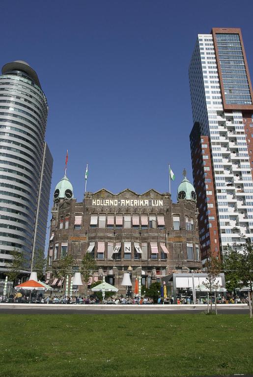 a building in the middle of a city with tall buildings at Hotel New York by WestCord in Rotterdam