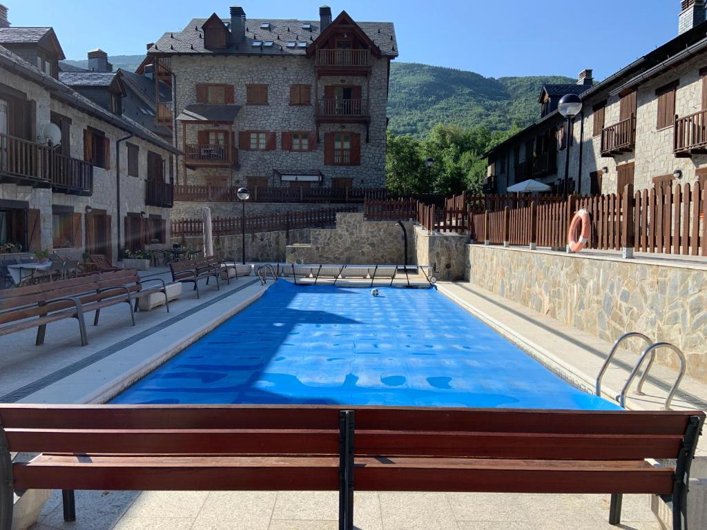 una gran piscina con bancos y un edificio en L06 - Casa Torres De Vallibierna - Villmor en Eriste