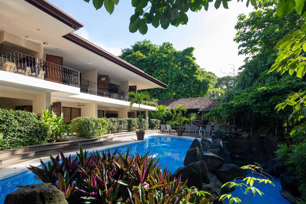 a swimming pool in the courtyard of a villa at Pumilio Mountain & Ocean Hotel in Jacó