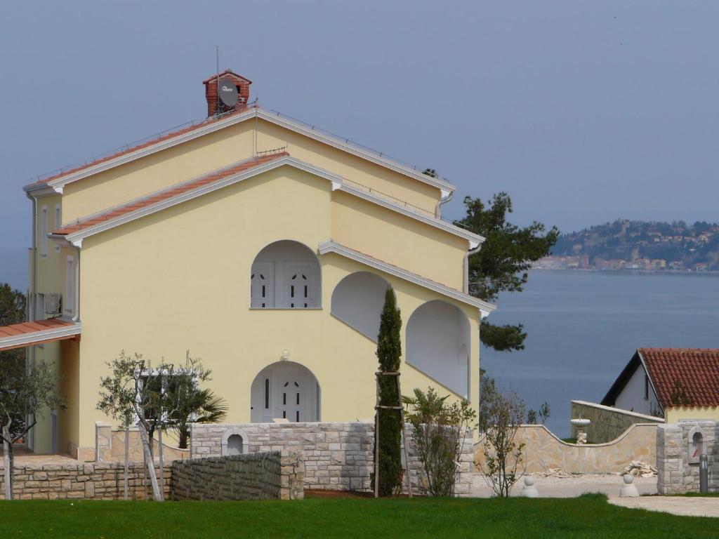 um pequeno edifício branco com uma cerca à volta em Villa del Golfo em Savudrija