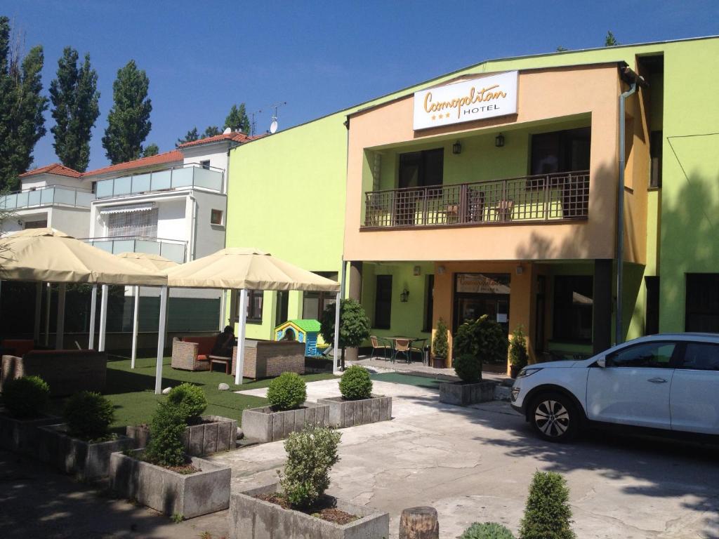 a white car parked in front of a building at Garni Hotel Cosmopolitan in Senec