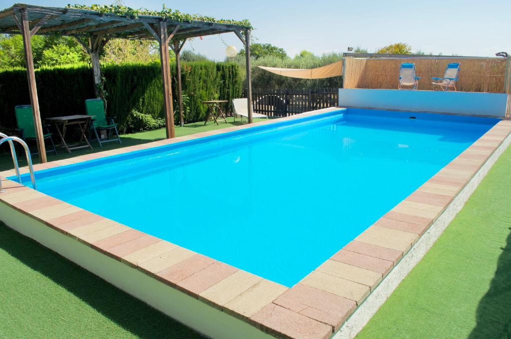 una piscina en un patio trasero con mesa y sillas en Los Olivos en Chiva