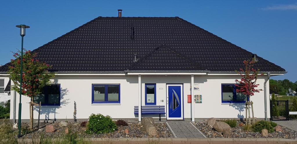 a white house with a black roof at Haus Kliffblick in Glowe