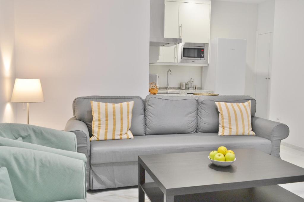 a living room with a couch and a table with a bowl of fruit at SunShine Cruz Conde in Córdoba