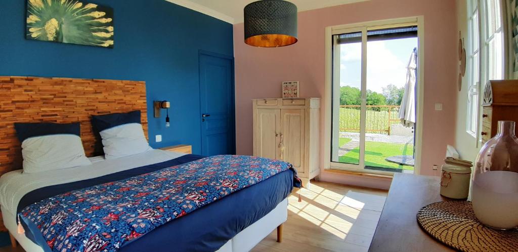 a bedroom with a bed with blue walls and a window at A L'OMBRE DE LA TREILLE -Proche Saint-Emilion in Saint-Magne-de-Castillon